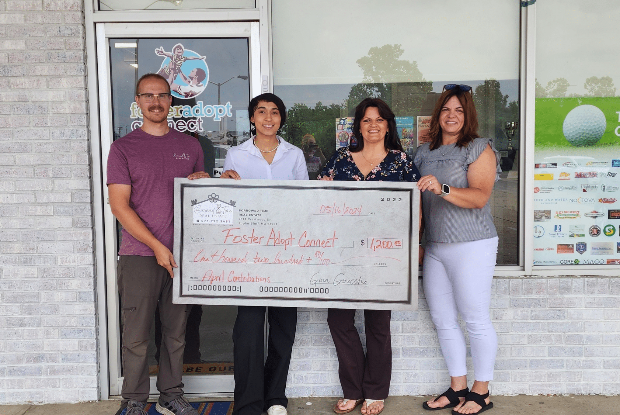 Borrowed Time Real Estate presents a donation check to FosterAdopt Connect in Poplar Bluff, Missouri.
