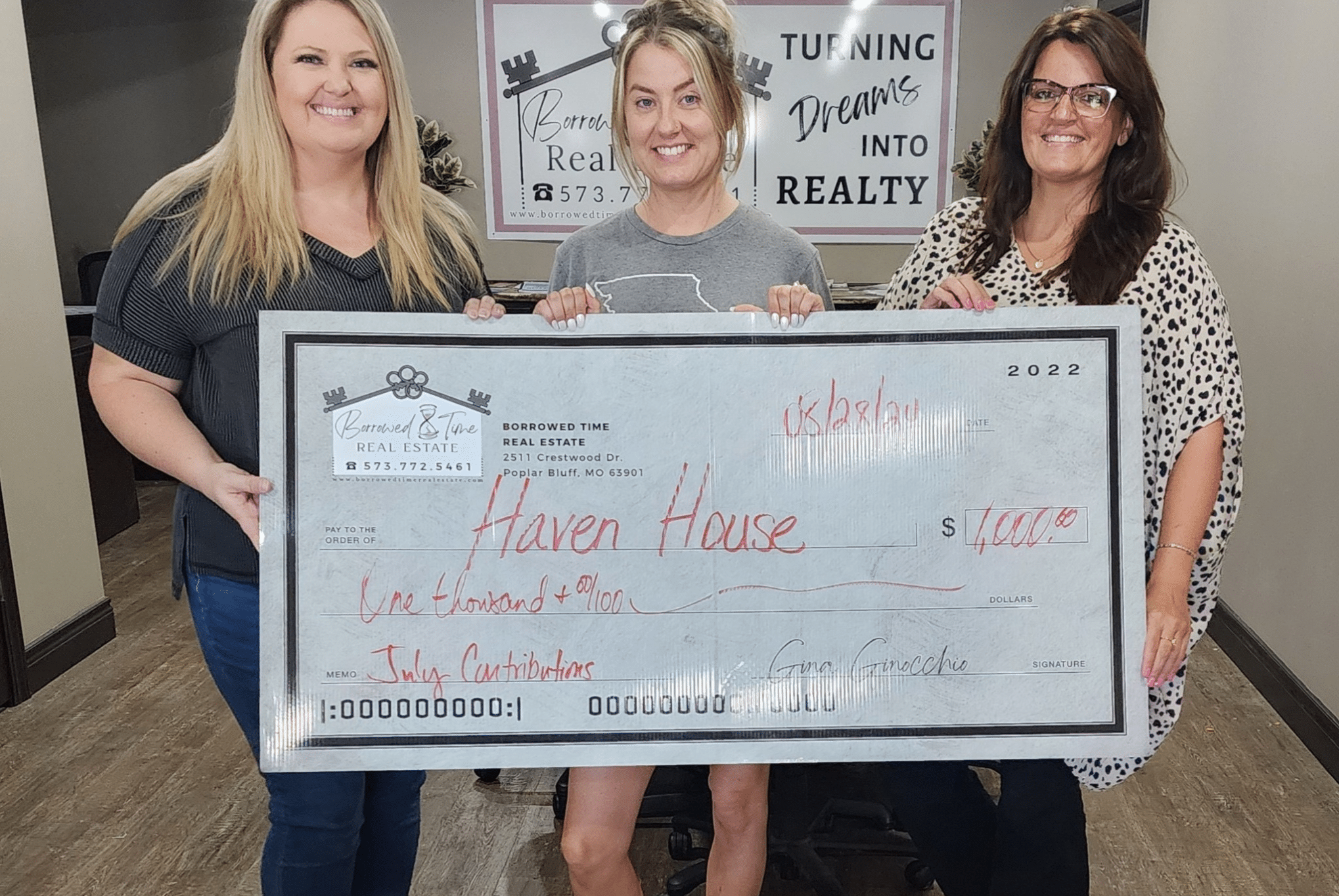 Borrowed Time Real Estate team holds a donation check for Haven House in Poplar Bluff, Missouri.