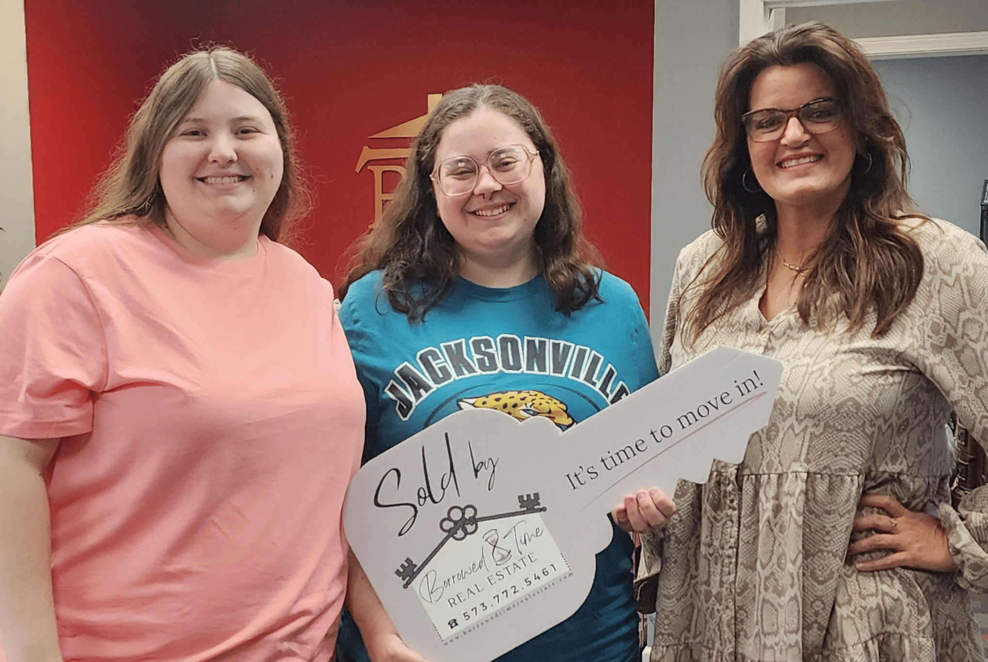 First-time homebuyers holding sold key sign after USDA loan closing