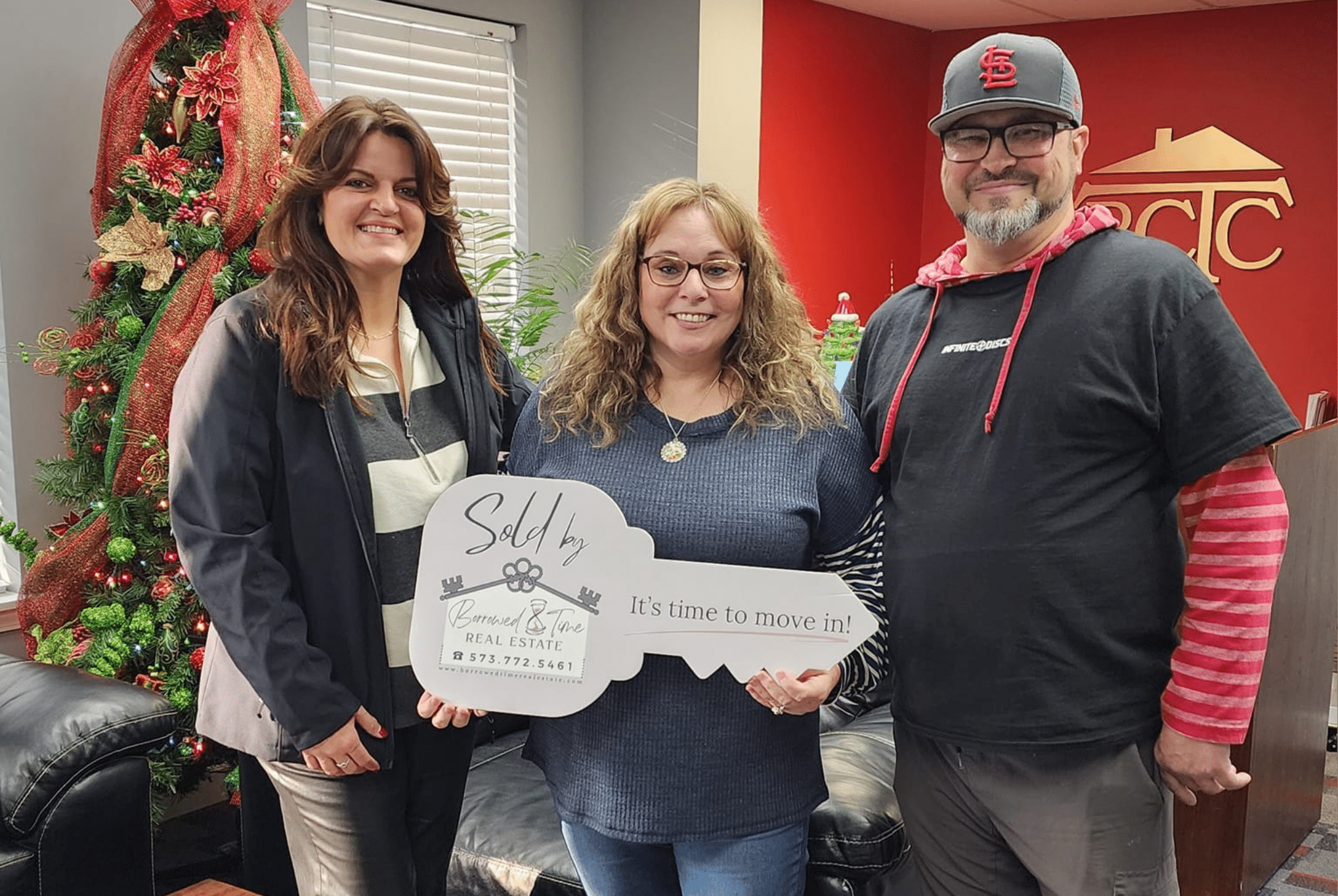 Homebuyers holding sold key sign during holiday season closing