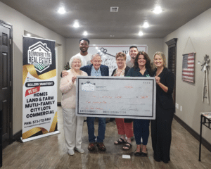 Poplar Bluff community members presenting donation check to Family Worship Center for family affected by contractor fraud in 2026
